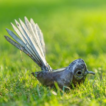 Metalen tuinbeeld van een piwakawaka, gemaakt door een Afrikaanse kunstenaar. 